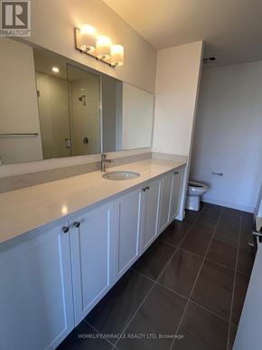 Clarington (Bowmanville) condo for rent - A bathroom with a sink, mirror, and toilet.