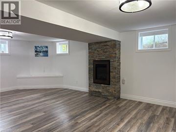Ancaster apartment for rent - A living room with a stone fireplace and wood flooring.