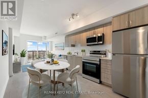 Toronto (Yorkdale-Glen Park) condo for rent - A modern kitchen with stainless steel appliances and a dining table set for four.