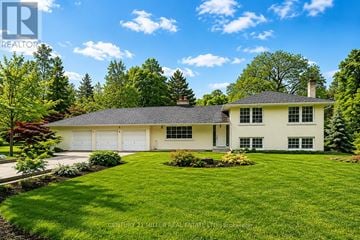 Oakville (Mo Morrison) apartment for rent - A white house with a grey roof and a green lawn in front.