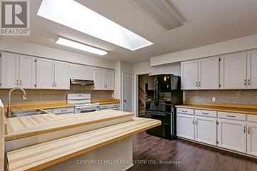 Oakville (Mo Morrison) apartment for rent - A kitchen with white cabinets and a black refrigerator.
