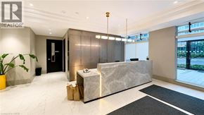 Kitchener condo for rent - A reception area with a marble counter and a plant in a yellow pot.