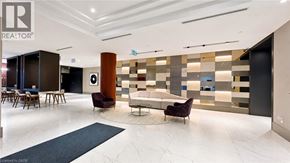 Kitchener condo for rent - A modern office lobby with a marble floor and a wooden reception desk.