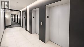 Kitchener condo for rent - A hallway with white doors and a black and white floor.
