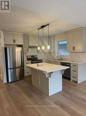 Wellington North (Mount Forest) townhouse for rent - A modern kitchen with a large island and stainless steel appliances.