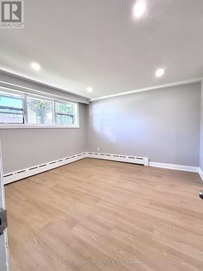 Toronto (Mimico) triplex for rent - A room with a window and wooden flooring.