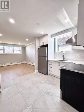 Toronto (Mimico) triplex for rent - A kitchen with a black refrigerator and white cabinets.