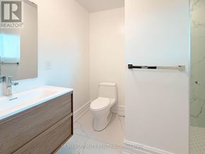 Toronto (Rustic) apartment for rent - A white toilet in a bathroom with a sink and a towel bar.