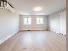 Toronto (Rustic) apartment for rent - A spacious room with wooden flooring and two windows.