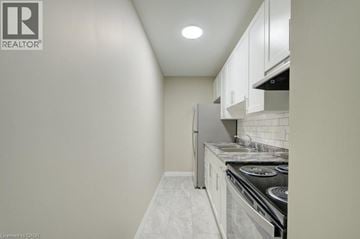 Cambridge apartment for rent - A small kitchen with white cabinets and a stove top oven.