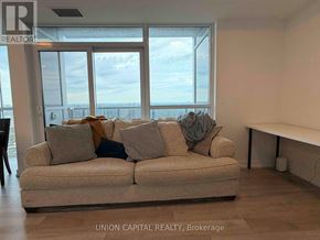 Toronto (Agincourt South-Malvern West) condo for rent - A living room with a couch and a view of the ocean through the windows.