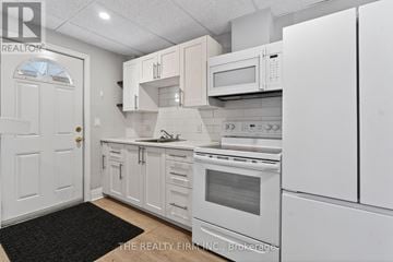 London East (East F) fourplex for rent - A white kitchen with a black mat on the floor.