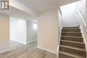 Hamilton (Westcliffe) apartment for rent - A room with wooden floors and a staircase leading to another room.