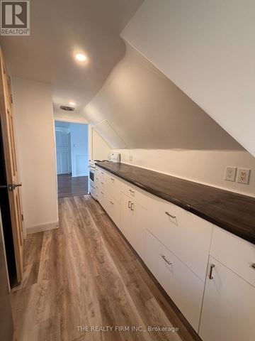 London East (East M) duplex for rent - A kitchen with white cabinets and a wooden floor.