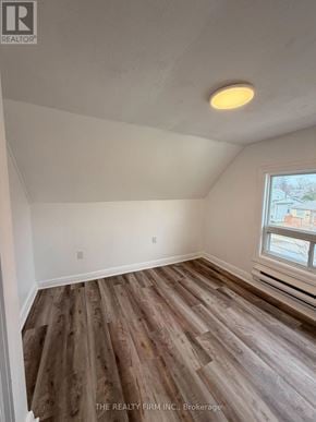 London East (East M) duplex for rent - A room with wooden flooring and a window.