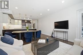 Mississauga (Clarkson) condo for rent - A modern living room with a dark wood coffee table and a large flat screen TV.