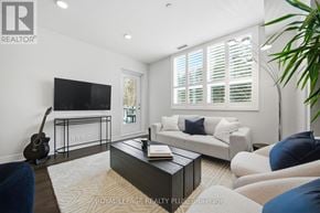 Mississauga (Clarkson) condo for rent - A living room with a guitar, a sofa, a coffee table and a plant.