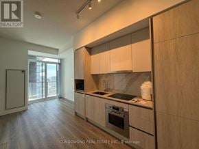 Toronto (Moss Park) condo for rent - A kitchen with wooden cabinets and a marble countertop.