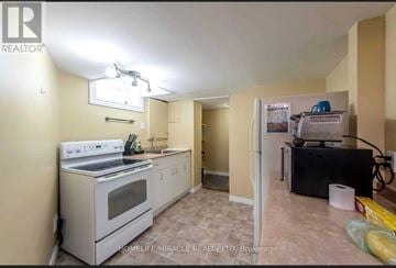 Thorold (Confederation Heights) apartment for rent - A kitchen with a white stove top oven and a black refrigerator.