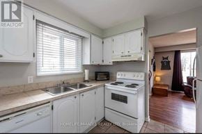 Thorold (Confederation Heights) apartment for rent - A kitchen with white cabinets and a white stove top oven.