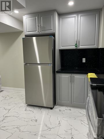 Pickering apartment for rent - A stainless steel refrigerator in a kitchen with marble flooring.