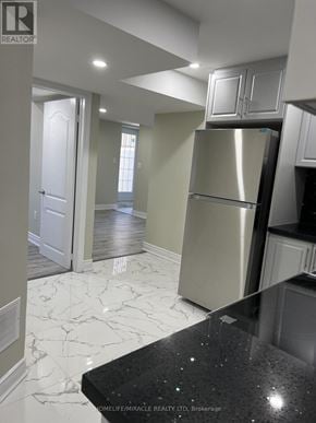 Pickering apartment for rent - A kitchen with a black counter top and a stainless steel refrigerator.