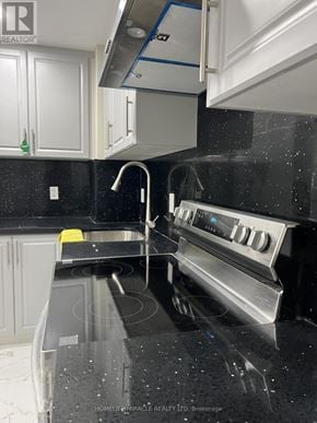 Pickering apartment for rent - A kitchen with a black counter top and white cabinets.
