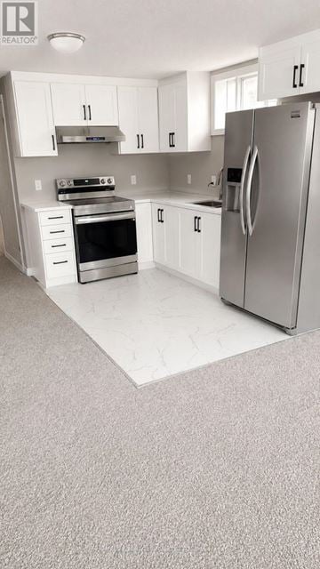 Kitchener apartment for rent - A white kitchen with a refrigerator, oven, and sink.