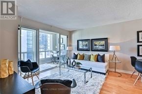 Toronto (Bay Street Corridor) condo for rent - A living room with a white couch, a coffee table, and a rug.