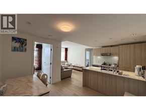 Vancouver apartment for rent - A well-lit kitchen and living room with wooden floors and furniture.