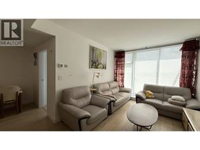Vancouver apartment for rent - A living room with a grey couch, a white table, and a painting on the wall.