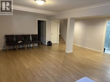 Burnaby apartment for rent - A living room with a brown couch and a white door.