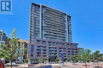 Toronto (Little Portugal) condo for rent - A tall building with a sign that says "Goldenway Real Estate" in front of it.