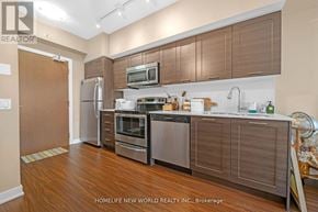 Toronto (Mimico) condo for rent - A modern kitchen with wooden cabinets and stainless steel appliances.