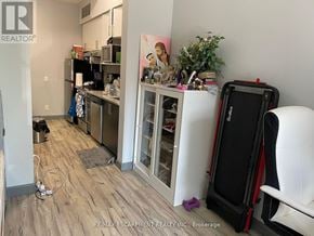 Hamilton (Ainslie Wood) condo for rent - A room with a white wall and a wooden floor with a white chair and a black suitcase.