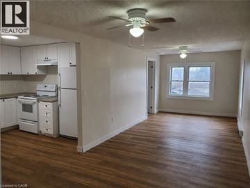 Welland apartment for rent - A realtor logo is on the wall in a kitchen and living room.