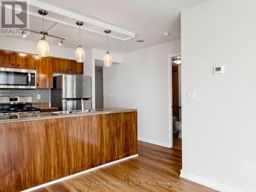 Toronto (Waterfront Communities) condo for rent - A modern kitchen with wooden cabinets and a stainless steel refrigerator.