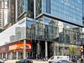 Toronto (Waterfront Communities) condo for rent - A large glass building with a red sign that says "REALTOR" on it.