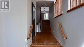 Toronto (Clairlea-Birchmount) townhouse for rent - A hallway with wooden stairs and a white wall.