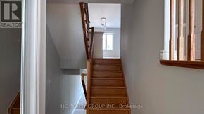 Toronto (Clairlea-Birchmount) townhouse for rent - A staircase in a house with a brokerage logo on the wall.