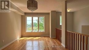 Toronto (Clairlea-Birchmount) townhouse for rent - A well-lit room with a chandelier, large windows, and wooden floors.