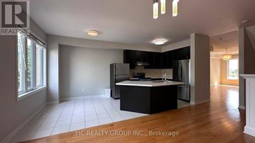 Toronto (Clairlea-Birchmount) townhouse for rent - A spacious kitchen with black cabinets and a central island.