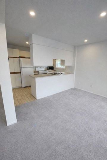 Gatineau (Hull) condo for rent - A white kitchen with a refrigerator, sink, and cabinets.
