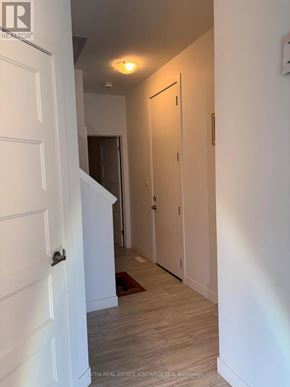 London North (North M) townhouse for rent - A hallway with a white door and a light on the wall.
