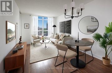 Toronto (Willowdale East) condo for rent - A living room with a round table and chairs, a rug, and a large window with a view of the city.