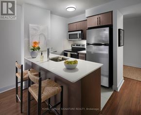 Toronto (Willowdale East) condo for rent - A kitchen with a white countertop and brown chairs.