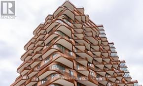 Toronto (Waterfront Communities) condo for rent - A tall building with a curved design and balconies on each floor.