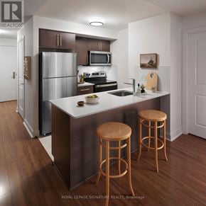 Toronto (Willowdale East) condo for rent - A kitchen with a refrigerator, microwave, oven, sink, and two stools.