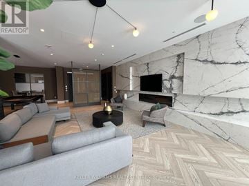 Oshawa (Windfields) condo for rent - A living room with a grey sofa and a marble wall.