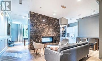 Toronto (Birchcliffe-Cliffside) condo for rent - A living room with a grey couch and a stone wall.